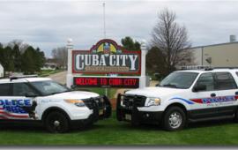Two Police Cars in front of Cuba City Sign
